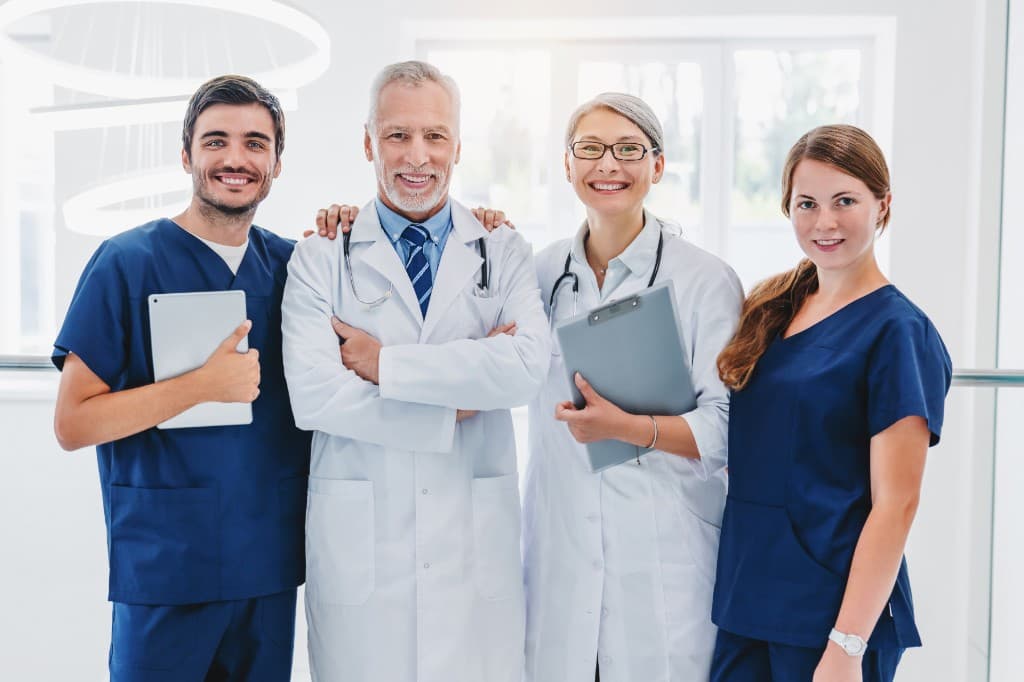 Medical team of doctors and nurses standing together in a bright clinic
